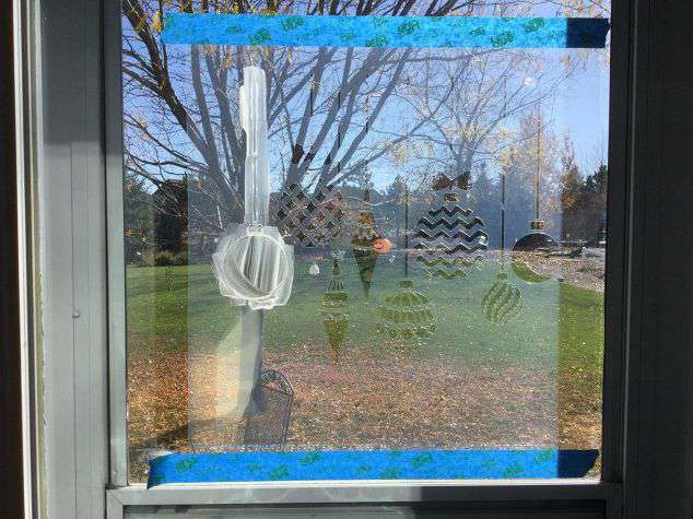 Tape your stencil to the window with the painters tape.