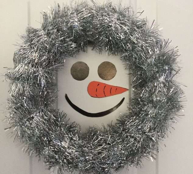 Next hang it on a door, refrigerator, or anything with metal on it. My wreath is hanging on a magnetic hook. This is a super easy project, and it's a great one for kids!