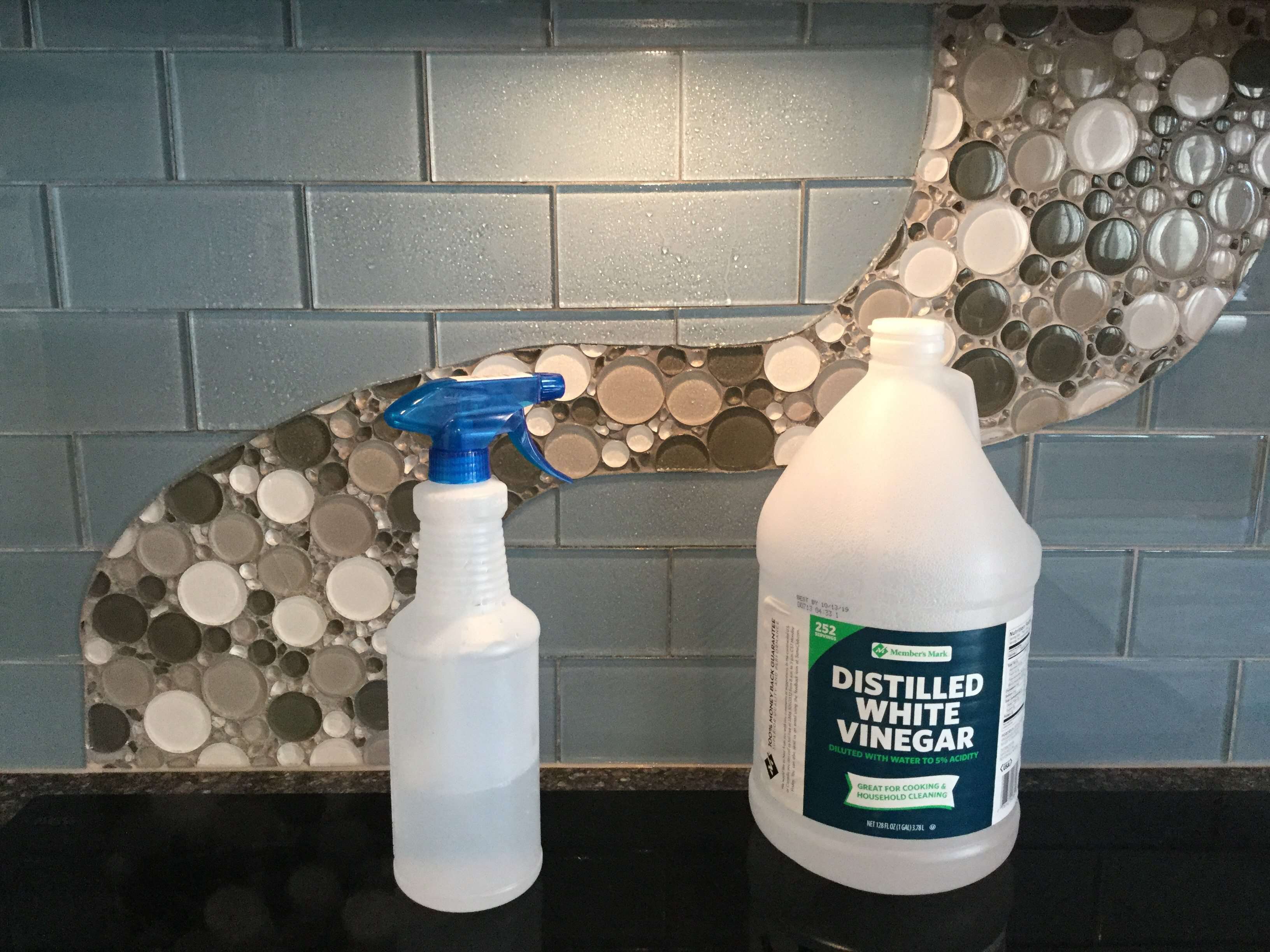 Pour your vinegar in the spray bottle. You can dilute it if you want, but don’t need to. The acidity in the vinegar will cut the grease and what will be disinfecting your back splash. Spray your back splash with the vinegar and wipe it down with a clean wash cloth (it’s important that it is clean or you will get streaks).