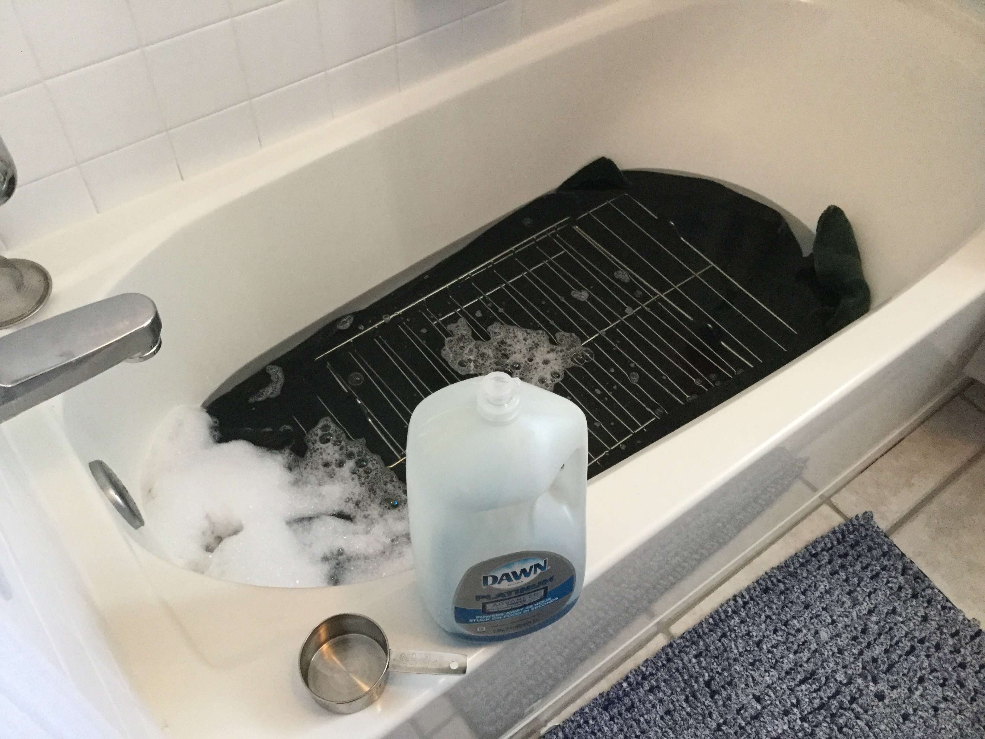 Place a towel in the bottom of your bath tub to protect your tub. Lay your oven racks on top of the towel. Add 1/2 cup dish soap (like Castile or Dawn) and fill the tub with hot water just until it covers the oven racks. Let them soak for 8 hours. The dish soap is cutting through all that grease.