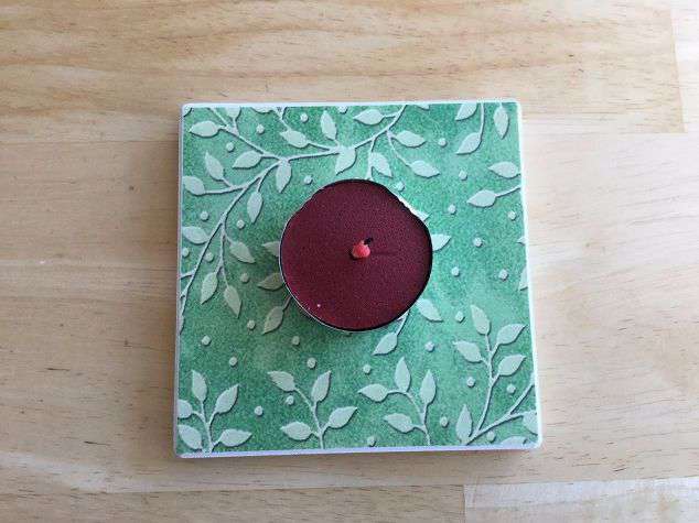 Set the tealight on the coaster. The coaster is for protecting your surface area from the heat.
