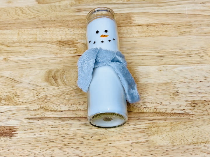 Step 7: Tie the Scarf Around the Candle Wrap the fabric scarf around the candle, tying it in a snug knot. Adjust the length and style of the scarf to suit your preferences and enhance the overall aesthetic of your snowman.