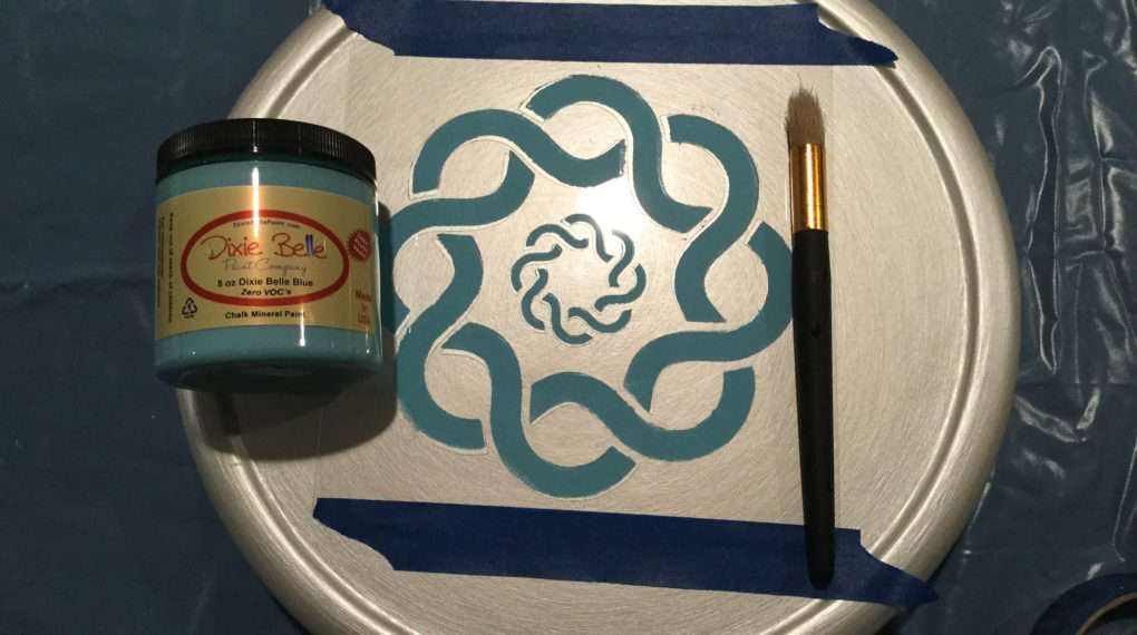 Place your Celtic Circle Stencil where you want it and set painter's tape on it to hold it in place. Dab paint the Dixie Belle Blue onto the Celtic Stencil