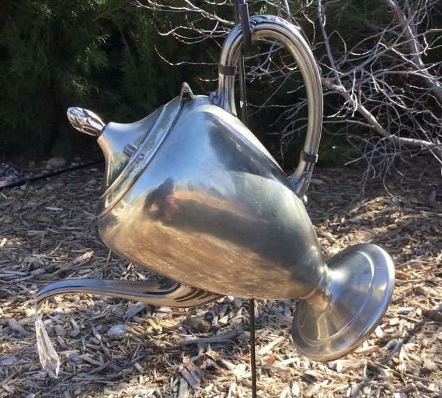 Place your garden hook in the ground and hang your tea/coffee pot on it.