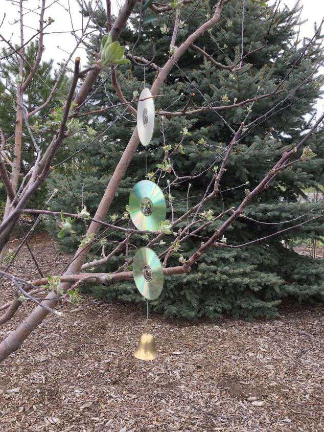 For my apple tree: I tied 3 used cds together with fish line. I added a loop at the top and hooked it on a plant hanging s hook. On the bottom I added a bell.