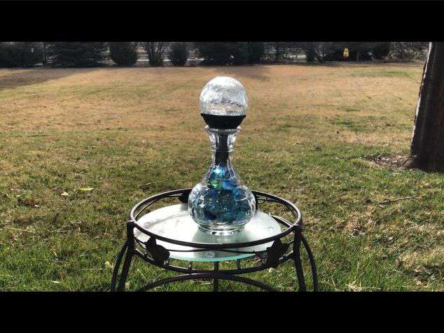 This one is a vase that I turned into a solar holder.  I added little glass flat rocks from Dollar Tree to the base, and added the sphere solar light from Walmart to the top.