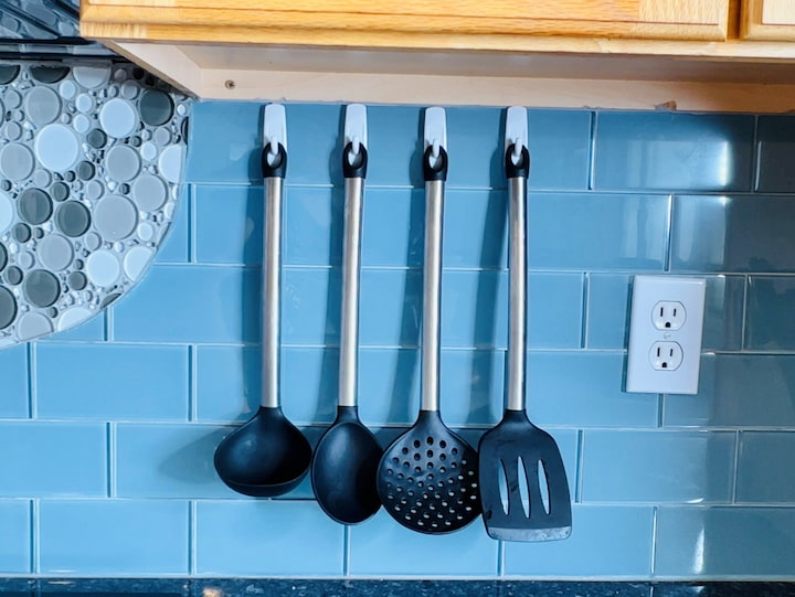 If you're short on space in your kitchen, you can use command hooks on your backsplash to hold items like your utensils.