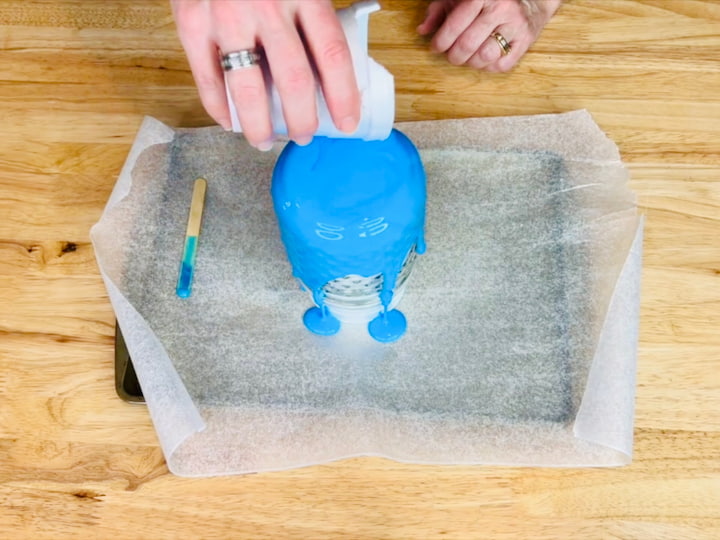 Pouring the glue and food color mixture over clear jar