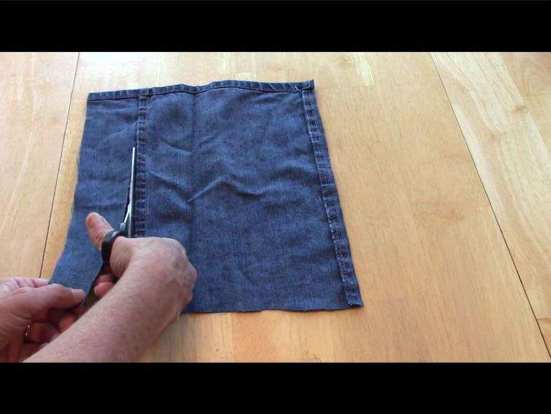 Cut off the bottom of the 2 legs of the jeans to use as the pockets on the pillow.  