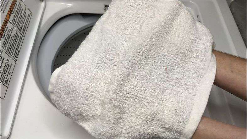 Placing towel in washing machine 