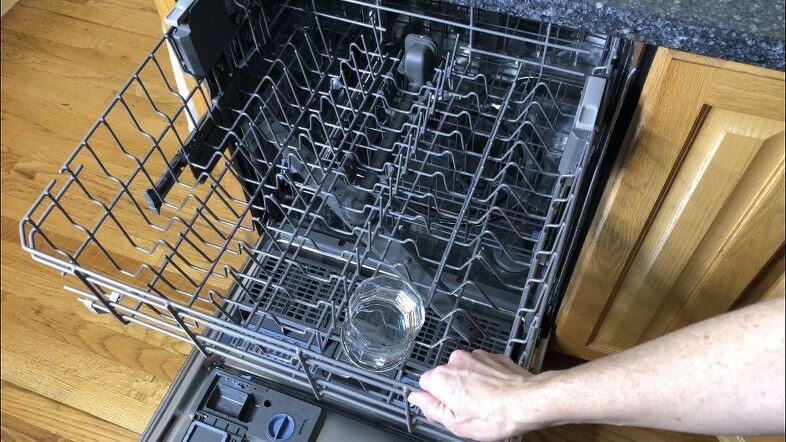 Place a cup full of vinegar in a cup on your top rack and run the dishwasher. It'll clean the soap scum and other junk out of it.