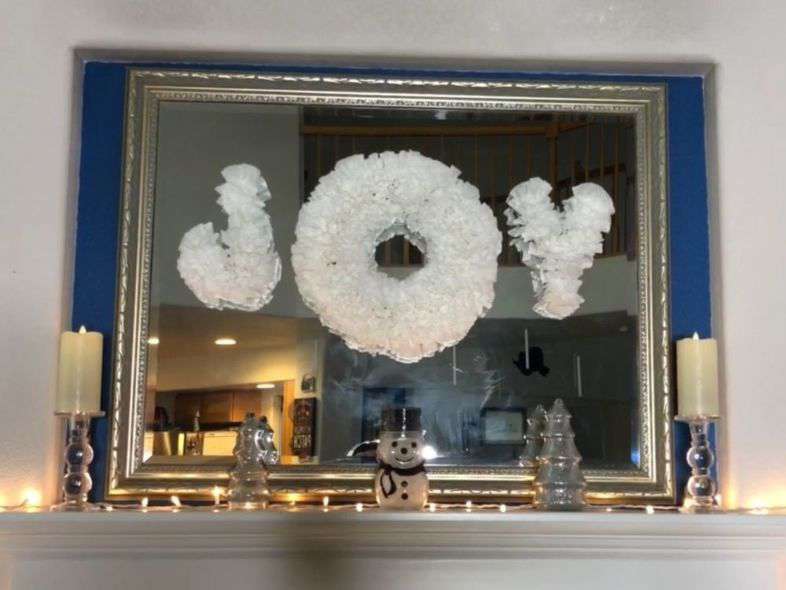 I cut the letters "J" and "Y" out of cardboard. I hot glued on some twisted coffee filters onto the letters until I had the look I wanted. I added my wreath from before to the center to be the letter "O" and created the word Joy. I used gaffers tape to hold up the letters and wreath onto my mirror.