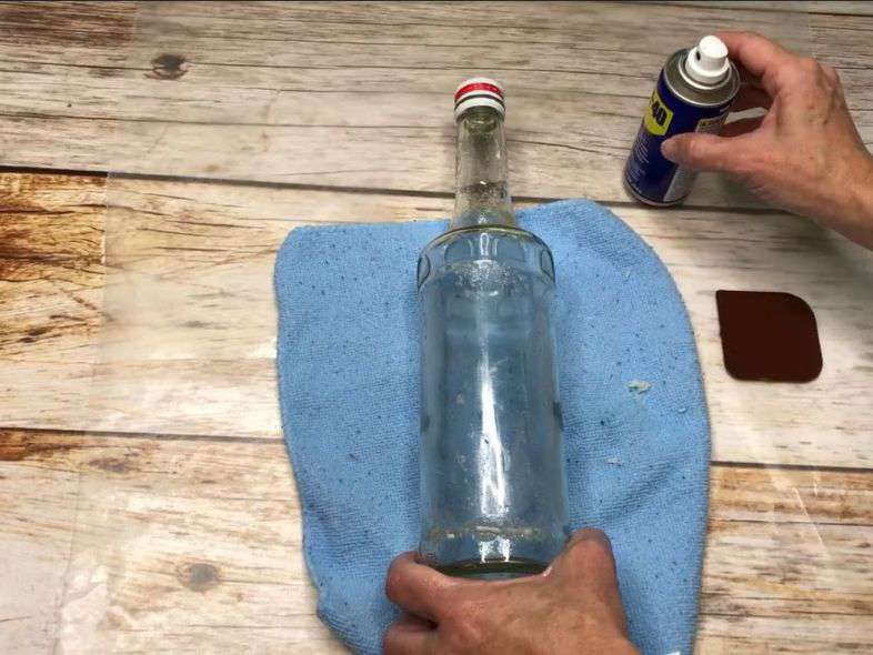 Spray it on and use a scraper to scrub it right off of bottles. Works great to remove tape residue as well.
