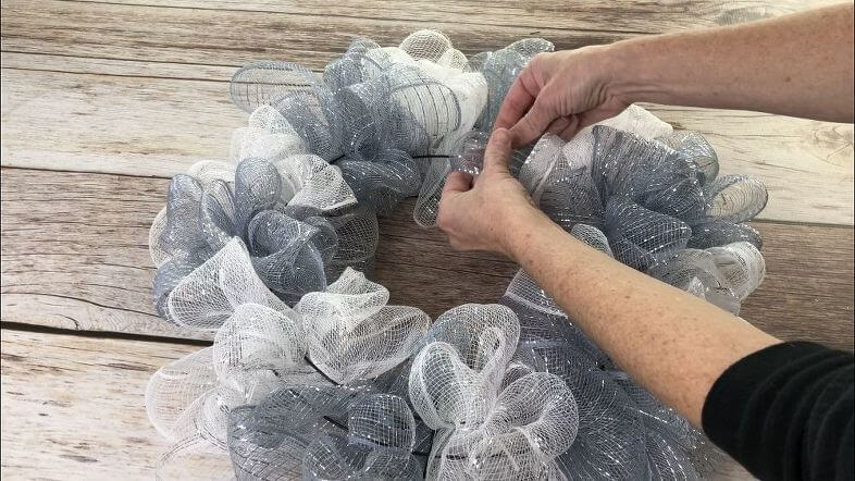 Now fluff your mesh. Widen, unwind, and spread apart each mesh loop to fill out our wreath.