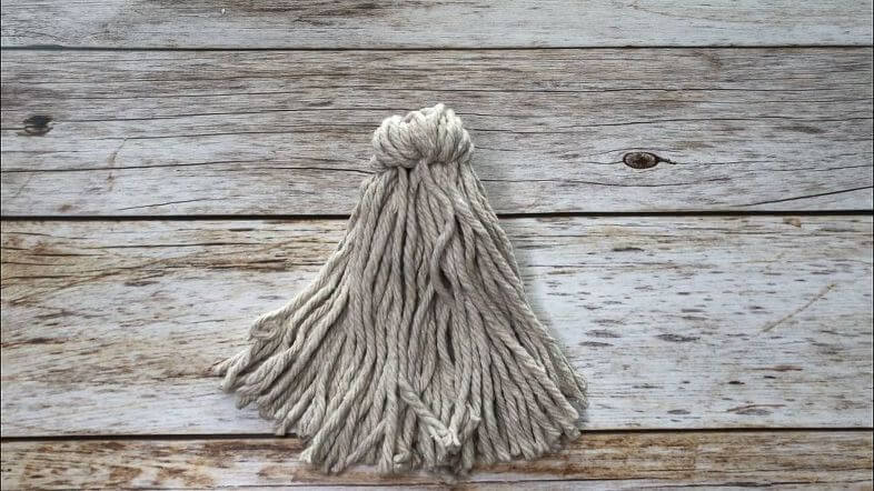 I took a portion of the mop strands and pulled them back behind the mop base and secured them like a ponytail with a rubber band.
