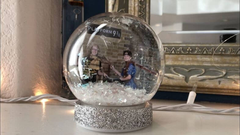 I found this plastic snow globe at Dollar Tree, I brought it home, cut a photo into a circle shape, put it inside, added some buffalo snow to the base, screwed on the bottom, and hot glued silver ribbon to the base.