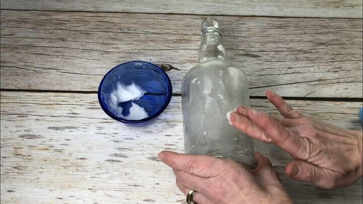 Rub coconut oil on and use a scraper to scrub it right off of bottles. 