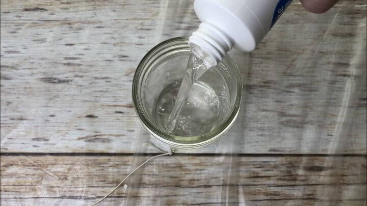Pour hairspray into a recycled jar.