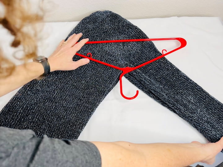 Here's how you can hang a sweater. Simply fold the sweater in half then move it diagonally. Flip one end of the sweater over the hangar and tuck it in and then flip the other side sweater side over and tuck it in. 