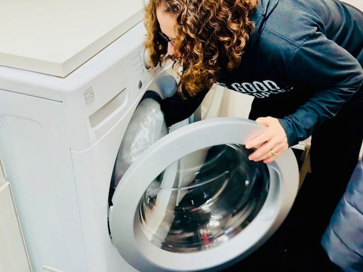 Chas placing shower curtain in the washing machine