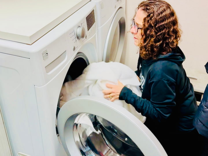 Chas adding towels to washing machine