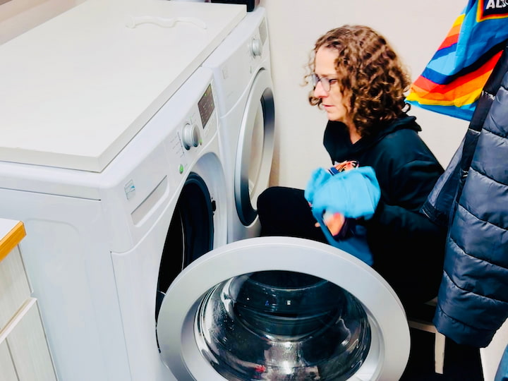 Chas placing workout clothes in the washing machine