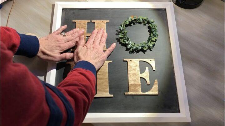 I pressed the letters, wreath and stencil tape onto the chalkboard so it held firm.