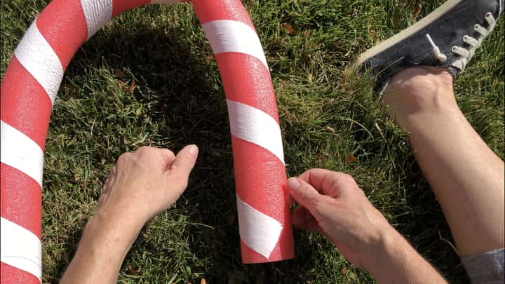 I curved the pool noodle into a candy cane shape and used fishing line to hold it in place.