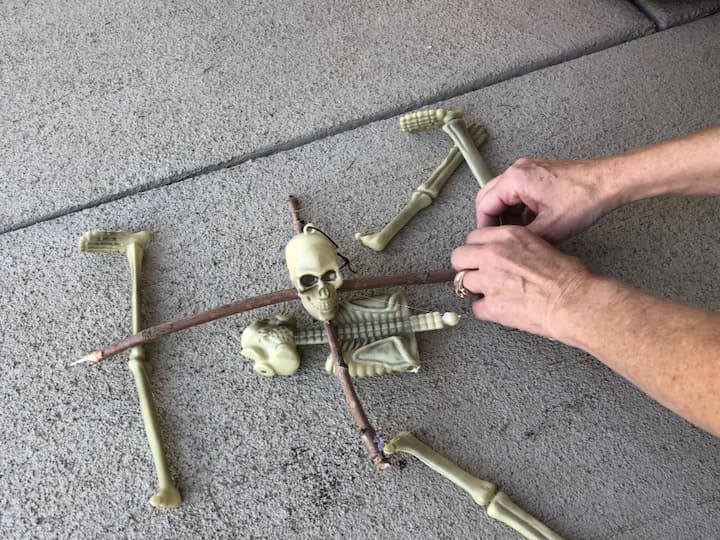 Tie pieces of fishing line to the other skeleton bones, and tie or hot glue those to the sticks.