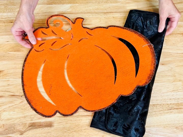 For this project I'm using a Dollar Tree pumpkin felt placemat, and one of their pillow covers.  Open the Dollar Tree pillowcase and place wax paper inside to prevent sticking. 