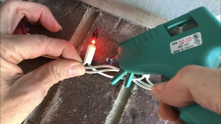 Hot glue your lights to your bricks on your home.