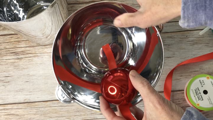DIY Outdoor Christmas Decorations Silver Bells - I bought 4 silver plastic ice buckets from the dollar store. I hot glued a red ribbon in the bottom of the bowl, and then hot glued a red bulb to the other end of the bulb.