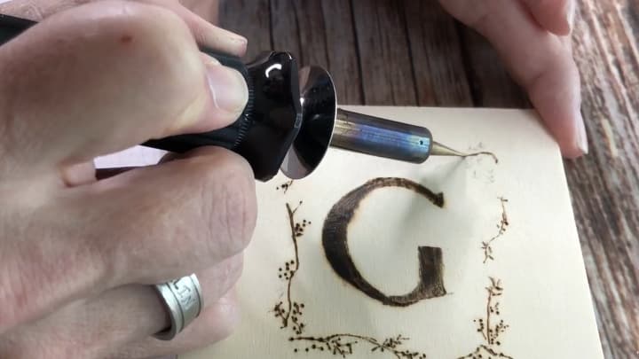 When my wood burning tool was cool enough, I changed the tips and re-heated it. I traced the transfer design with the tool.