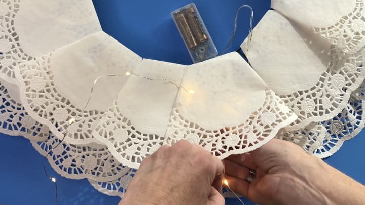 I then took a battery operated light strand and put it between the inside and outside rings of doilies. I hot glued the battery pack on the back.