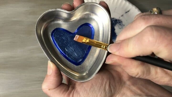 This is the old jello mold I found at the thrift store. I used the nautical paint on the center heart and let that dry. I traced the outer edge with blue permanent marker. Then I gave the whole blue section a coat of Sparkle Mod Podge to add some shimmer.