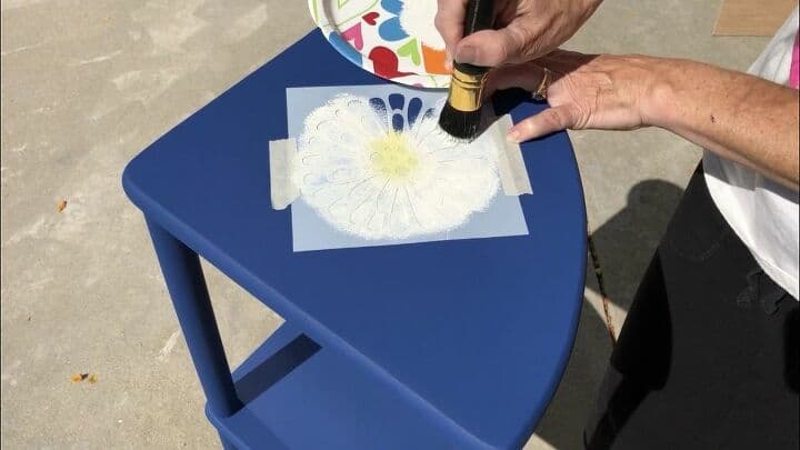 I then used Folk Art Home Decor Chalk Paint in the color Sheepskin to continue the daisy look finishing the stencil. Once the paint was on, I carefully peeled the stencil away. I washed the stencil while the paint dried so I could use it later.