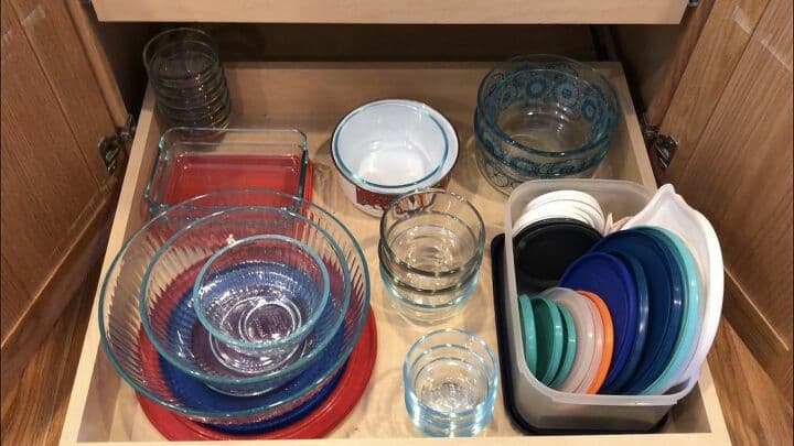 This is the bottom drawer in one of my cabinets. I have a lot of Pyrex glass wear and stacking is one of my big secrets. Under my big mixing bowls, I stacked the lids, then placed the bowls on top. The other containers I stacked the like sized bowls/containers, and I used a separated plastic container to keep all of the lids organized.