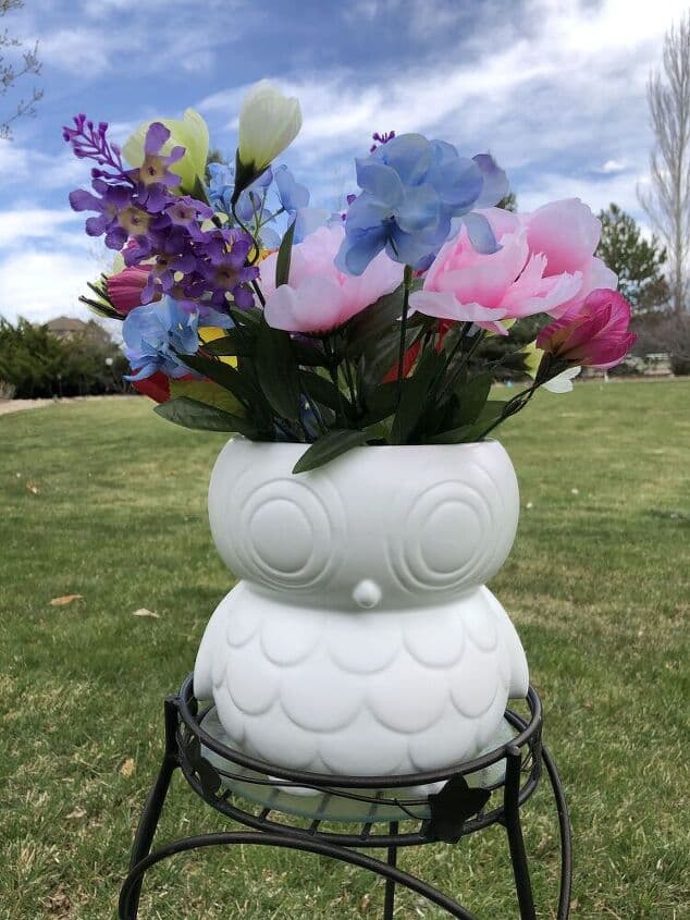 Adding a plant to a thrift store owl that has been spray painted.