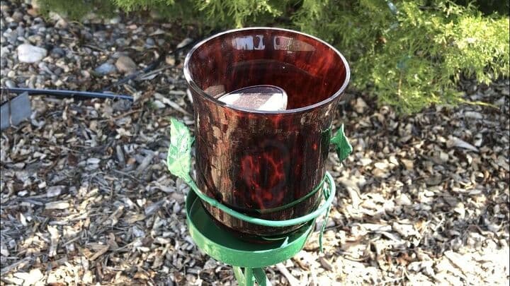 Once the paint dried I placed a red candle holder on top. I pulled the base off of a dollar store solar light and put it inside the red candle holder for added glow.