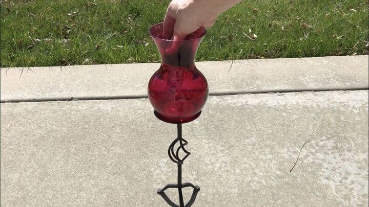 I glued this red vase that I also found at the same thrift store to the candle holder using silicone. I pulled the base off a dollar store solar light and placed it in the vase.