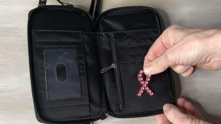 On the inside of the wallet I could have stenciled another spot on this pocket.  I decided to add a breast cancer awareness ribbon sticker I got from Dollar Tree.  It is in honor of my breast cancer journey.