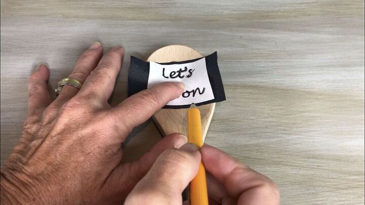 I purchased a wood spoon from Walmart. I cut a square of carbon paper and placed it on the spoon with the carbon side down. I printed out the woods "Let's Spoon" onto a piece of paper and placed that onto the carbon paper. I then used a pencil and traced the words.