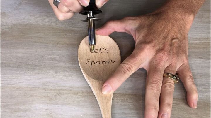 The carbon left the words onto the spoon. I then warmed up my wood burning tool, and I traced the carbon letters with the wood burning tool.