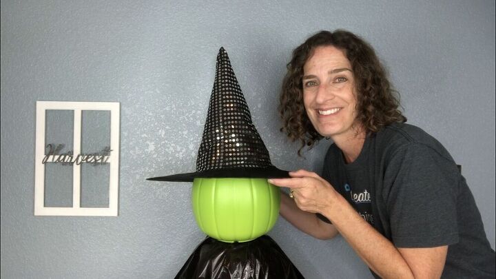 I added a witch hat to the top of the pumpkin pail. If you put an LED light inside you'll need to be able to reach inside and turn it on. If you aren't putting a light inside you can hot glue the hat to the head. To make the hat stick up right I filled it with a couple recycled grocery bags.