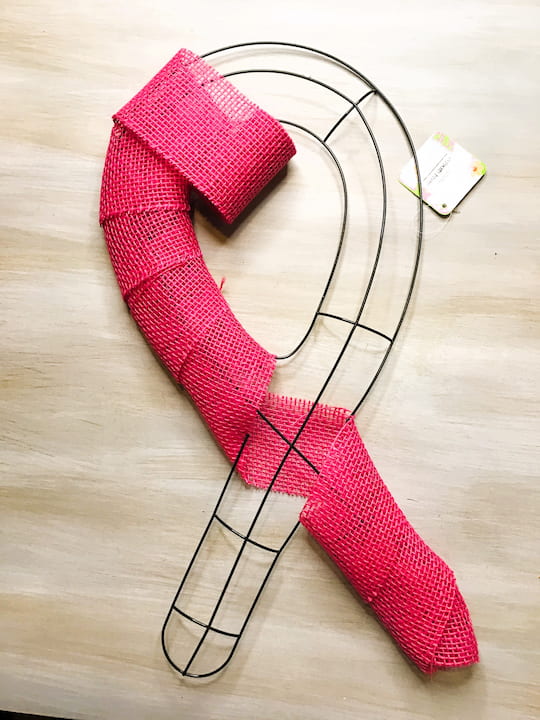 Begin by placing battery-operated LED lights on the wreath form. Wrap pink burlap ribbon around the entire wreath form.