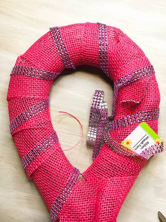 Decorate the wreath by adding Diamond wrap ribbon. Wrap it around the wreath form and secure it with hot glue.