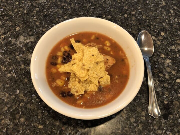 To serve, place soup in a bowl, top with shredded cheese and crushed tortilla chips.
