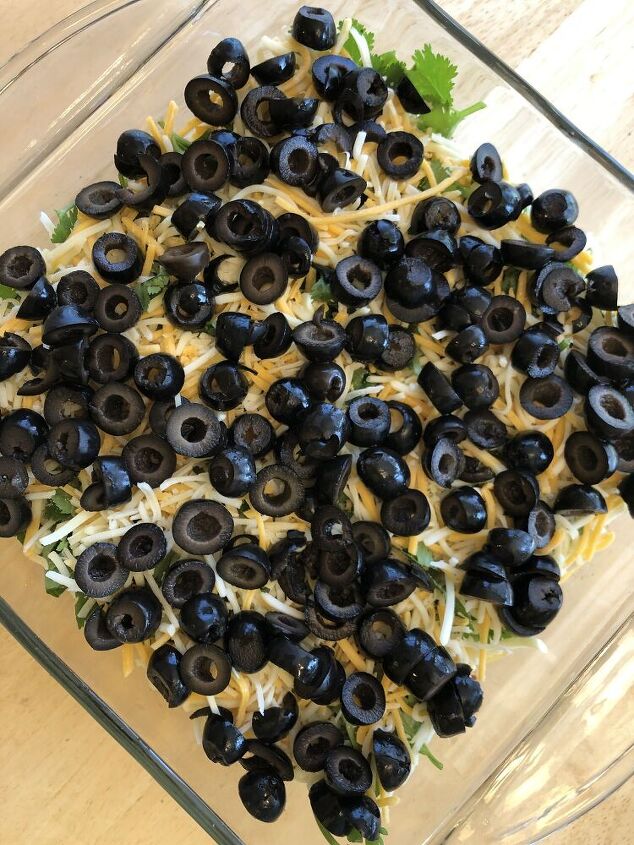 Mix the black beans and the taco seasoning together Place the beans on the bottom of an 8x8 baking dish Add the layers in the following order -  1 cup non fat plain Greek yogurt 1 cup salsa 1 cup chopped fresh cilantro 1 cup shredded cheese Sliced olives Refrigerate until ready to serve Serve with tortilla chips
