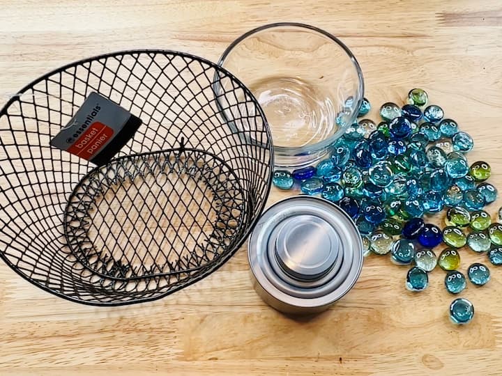 For this project you're going to need some Dollar Store rocks, a Sterno can, a basket of your choice, and then a glass container of your choice as well.