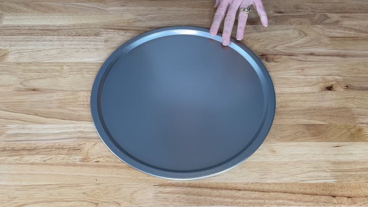 I started with a pizza pan from Dollar Tree.  Now to be honest, this pizza pan was actually one of my old ones and I had updated to a new one for my kitchen.  I cleaned it up and got it ready to paint.